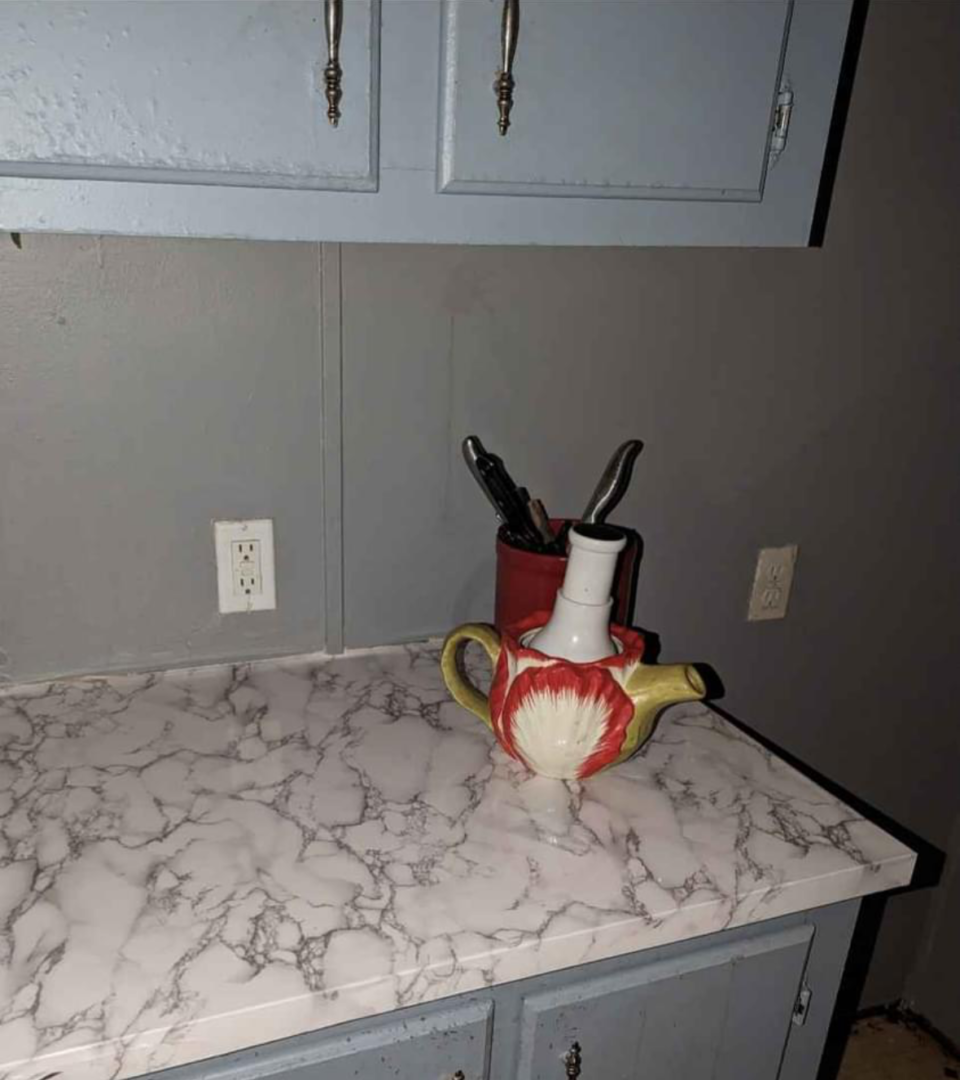 A colorful teapot on a marble countertop.