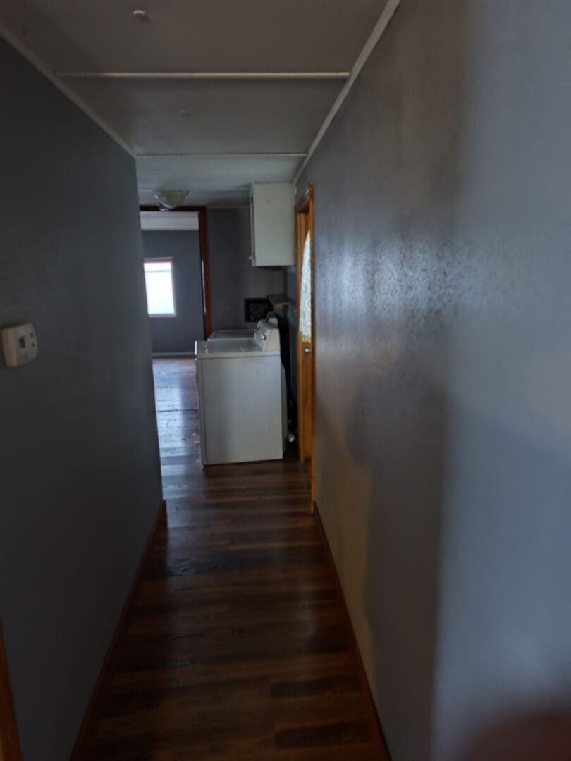 Hallway with wood floor and laundry room.