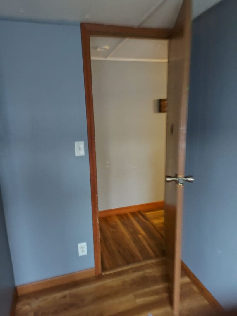 Open doorway to a room with wood floors.