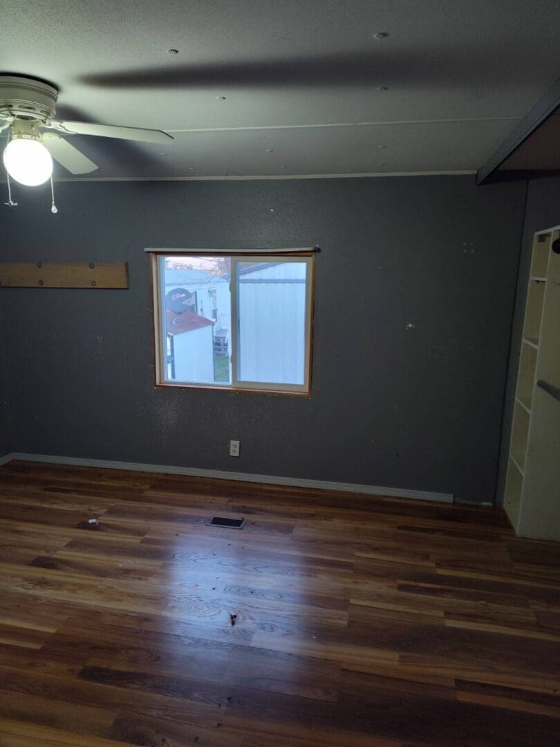 Empty room with hardwood floors and a window.