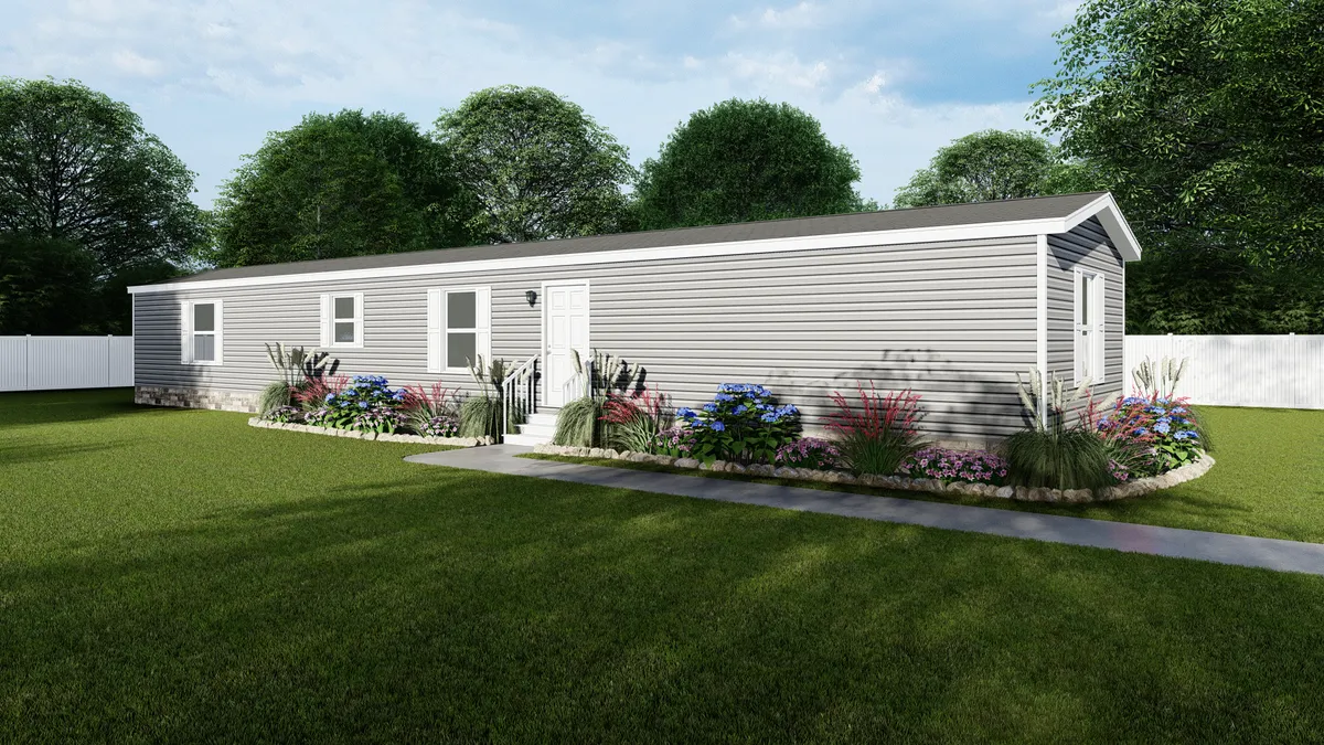 A gray manufactured home with a yard.