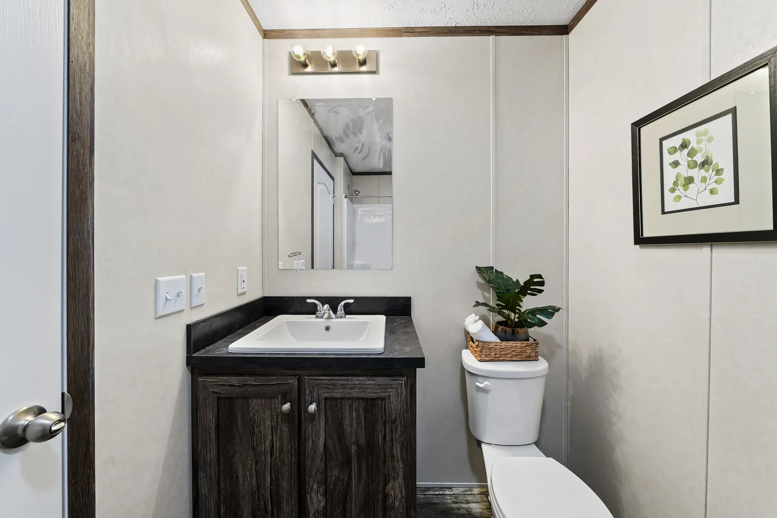 A small white bathroom with a sink and toilet.