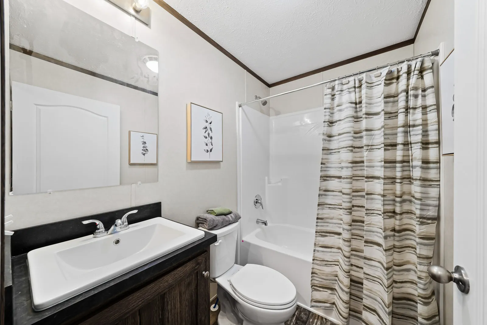 White bathroom with shower curtain and sink.