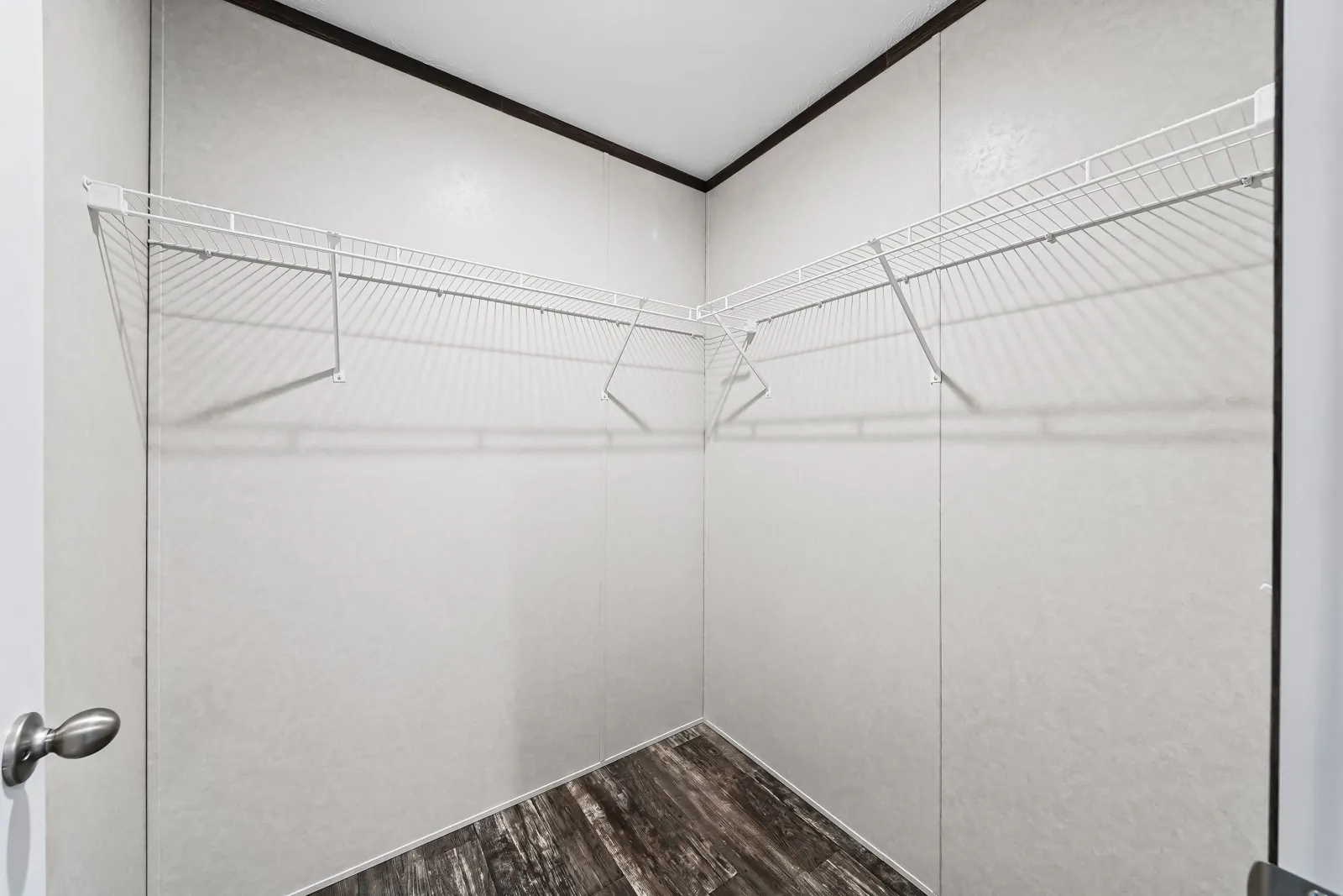 Empty white closet with wire shelves.